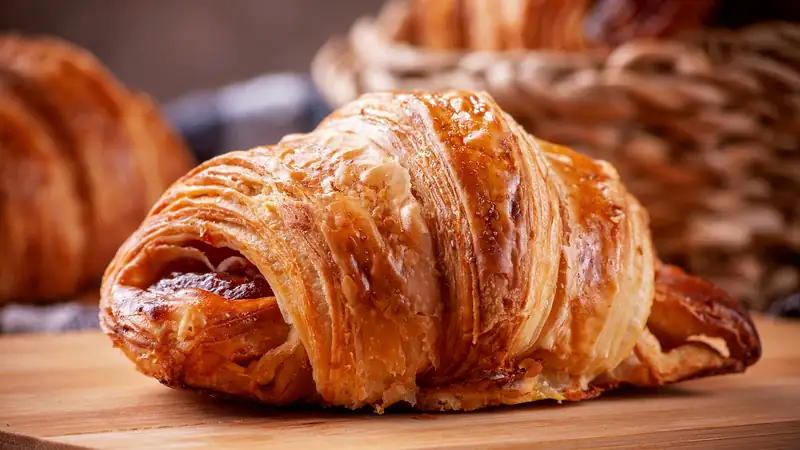 This morning out of the oven: laminated pastry still warm, the layers open at the ends, in the basket behind the counter.