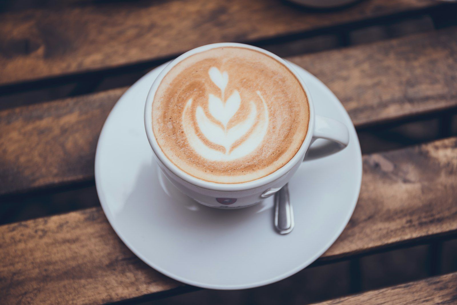 A cup of coffee with a rosetta poured into the crema, seen from above